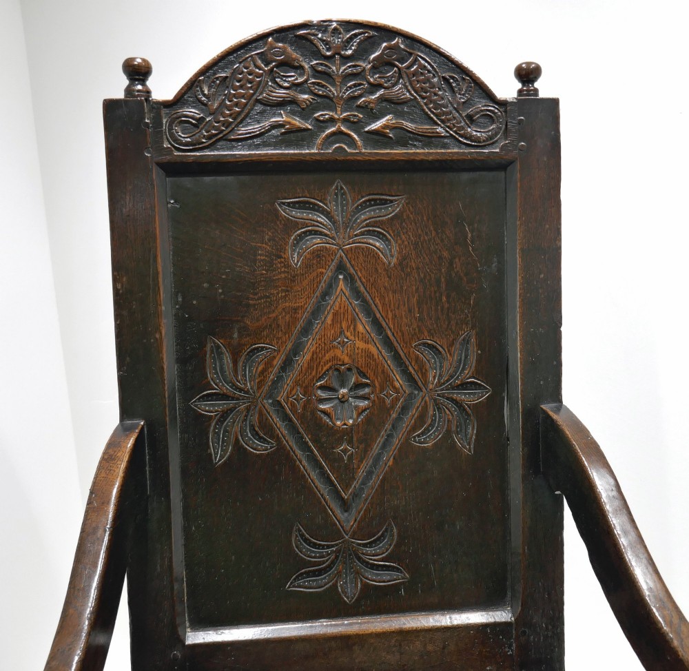 A 17th-century dark oak joined wainscot armchair featuring a carved lozenge back panel, turned front legs, scrolled arms, and a carved top rail. View II