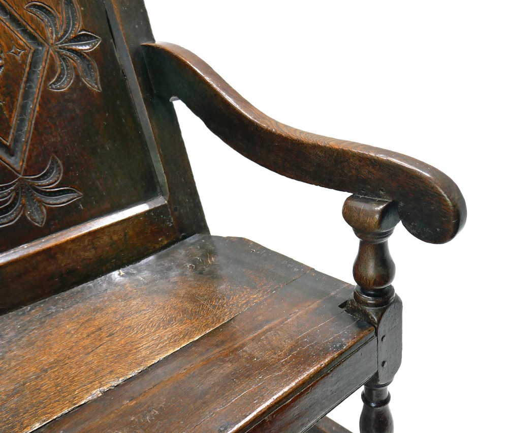 A 17th-century dark oak joined wainscot armchair featuring a carved lozenge back panel, turned front legs, scrolled arms, and a carved top rail. View III