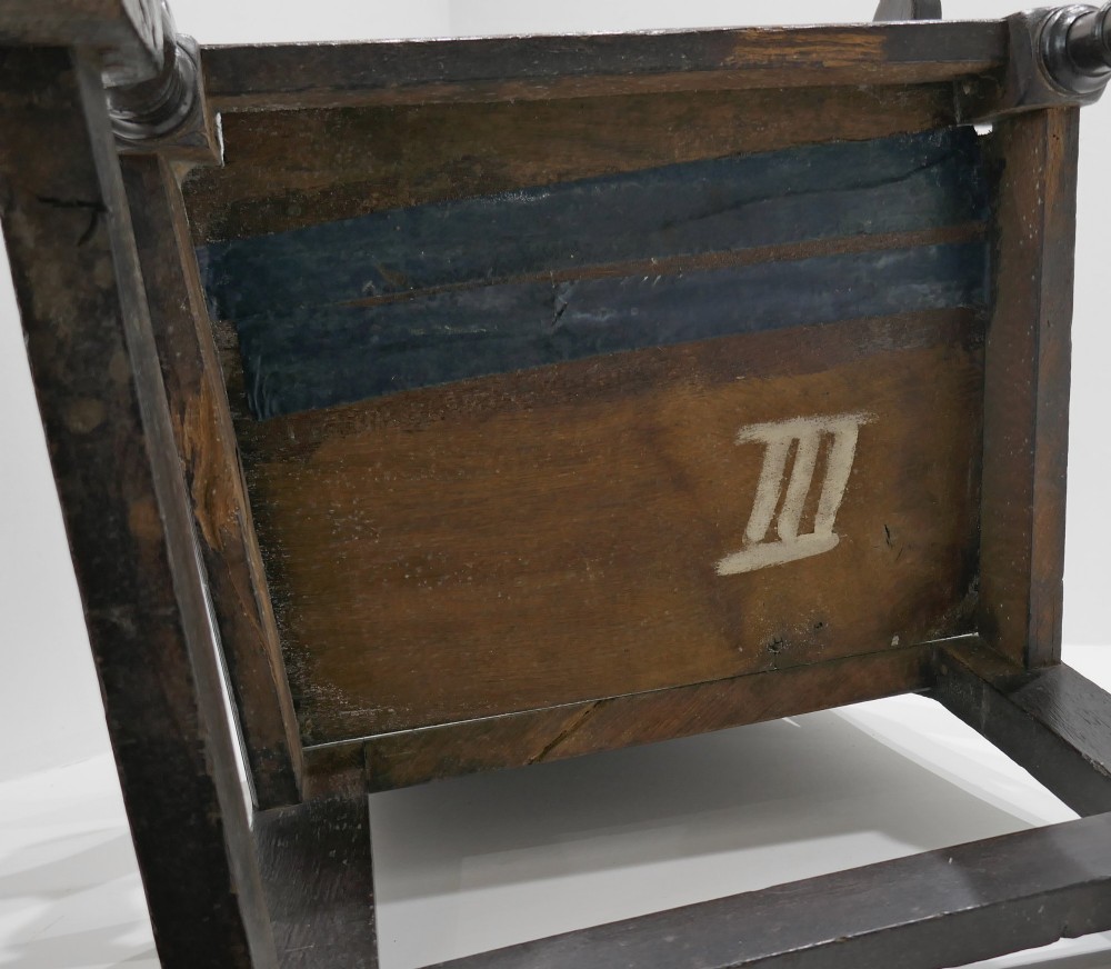 A 17th-century dark oak joined wainscot armchair featuring a carved lozenge back panel, turned front legs, scrolled arms, and a carved top rail. View VI