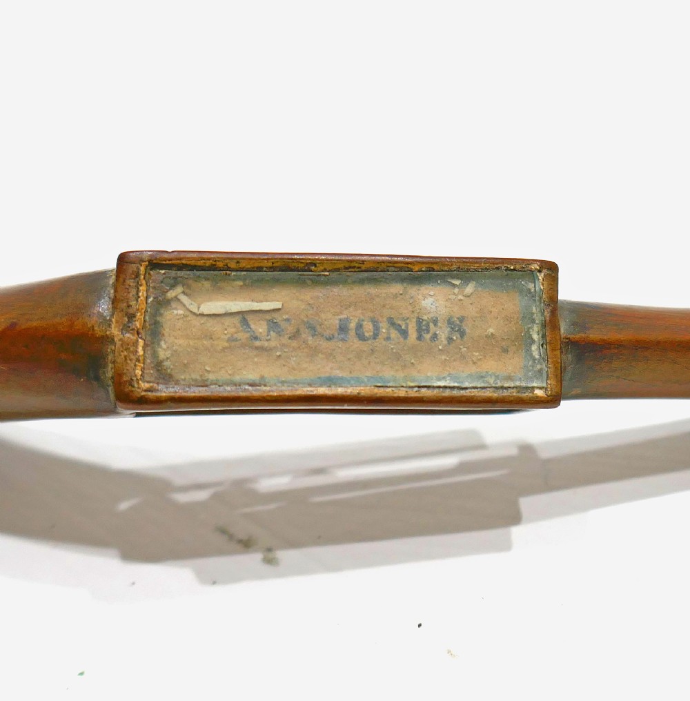 A carved fruitwood Welsh love spoon featuring an oval bowl, a framed name panel inscribed Ann Jones along the handle, and carved wooden chain links at the terminal. View III