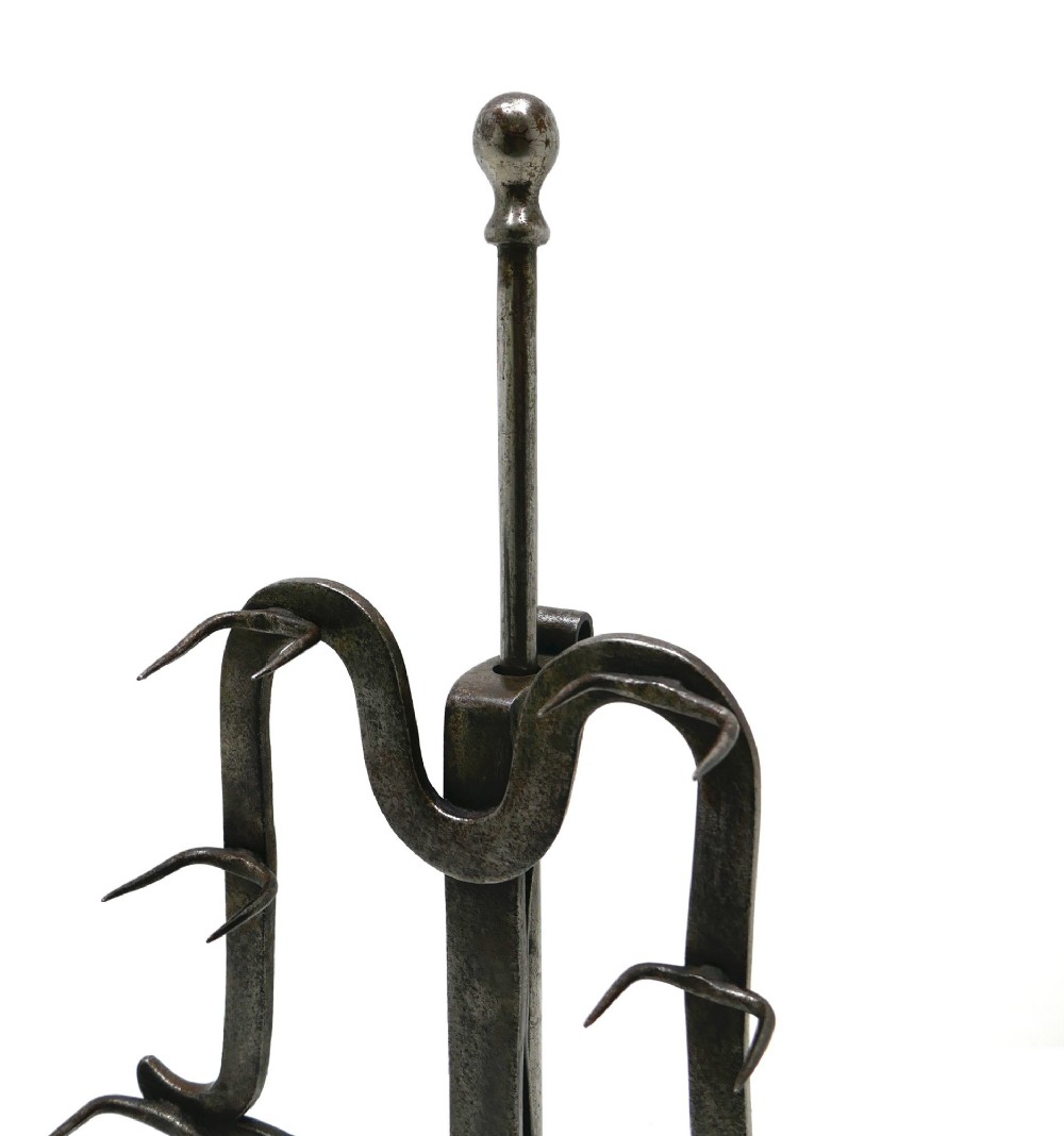 An eighteenth-century wrought iron adjustable lark spit toaster featuring a tripod base with rolled feet, a central vertical stem, and six pointed prongs. View IV