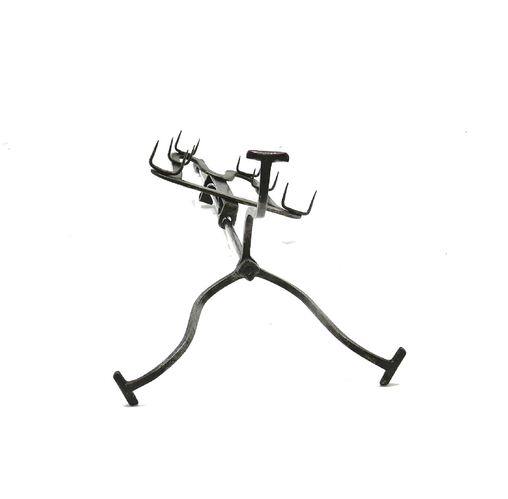 An eighteenth-century wrought iron adjustable lark spit toaster featuring a tripod base with rolled feet, a central vertical stem, and six pointed prongs. View VI