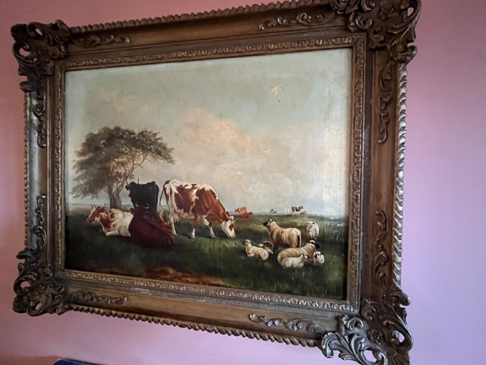 A Victorian oil painting on canvas depicting cattle and sheep resting in a field, presented within an ornate carved gilt moulding frame.