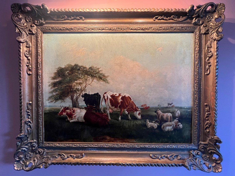 A Victorian oil painting on canvas depicting cattle and sheep resting in a field, presented within an ornate carved gilt moulding frame. View VI