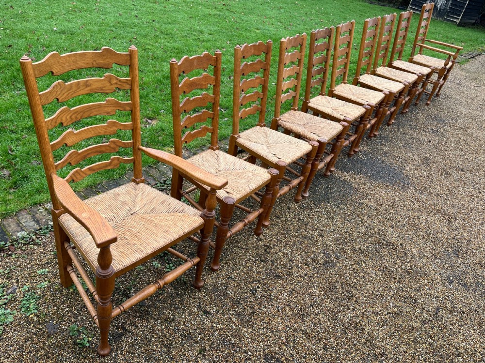 A set of ten antique oak ladder back dining chairs featuring woven rush seats and turned legs, comprising eight side chairs and two carver armchairs. View III