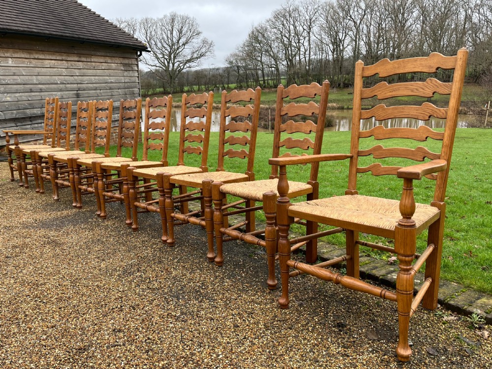 A set of ten antique oak ladder back dining chairs featuring woven rush seats and turned legs, comprising eight side chairs and two carver armchairs. View IV