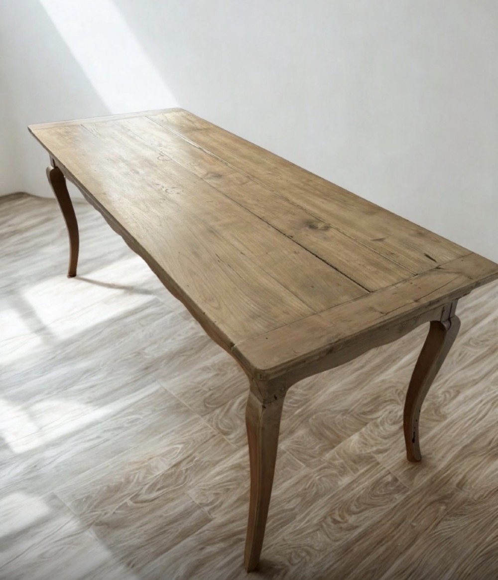 A late nineteenth-century French cherrywood dining table featuring curved cabriolet legs, a planked top, and an apron drawer. View II