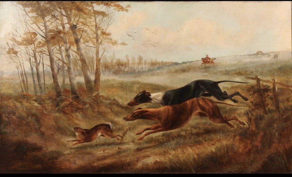 A nineteenth-century oil painting on canvas depicting two greyhounds in full motion chasing a hare across a grassy landscape within a carved gilt frame. View II