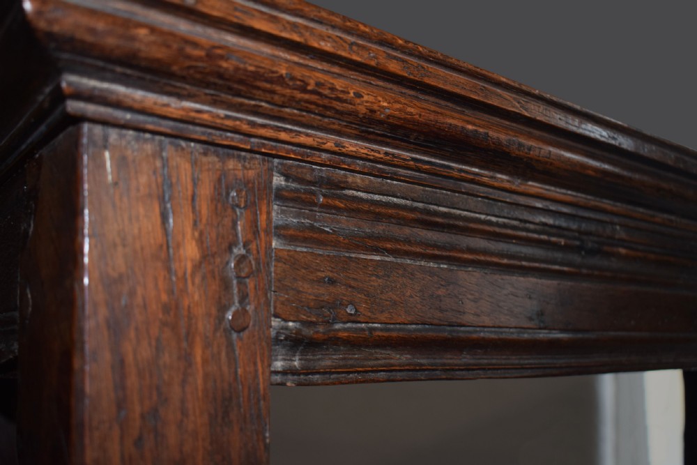 A three-tier dark oak Welsh tridarn dresser featuring carved frieze panels, baluster supports, and lower cupboard doors. View IV