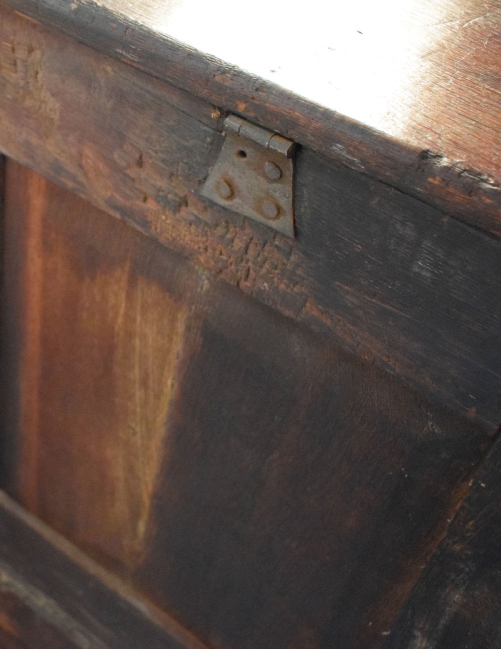 A dark oak antique mule chest featuring four arched fielded panels, two lower drawers with brass drop handles, and bracket feet. View VII