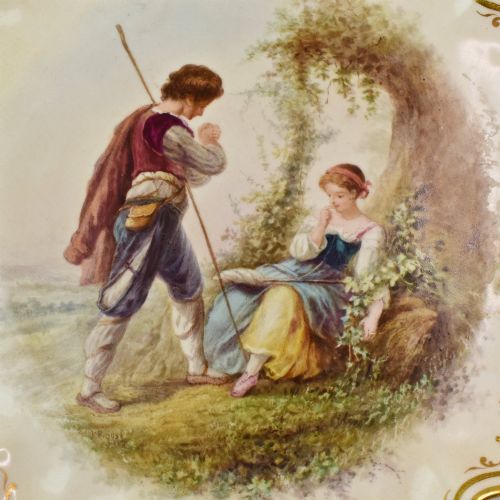 fig 2. A circular Victorian porcelain cabinet plate featuring a hand-painted romantic pastoral scene enclosed by a lobed rim decorated with gold gilding.