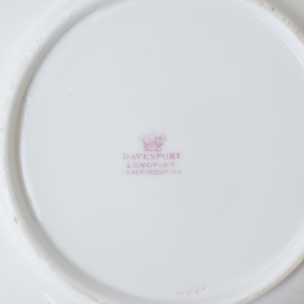 A Victorian Davenport porcelain true trio featuring a stacked tea cup and coffee cup decorated with intricate hand-painted rust red and gold ornamentation resting on a matching saucer. View X