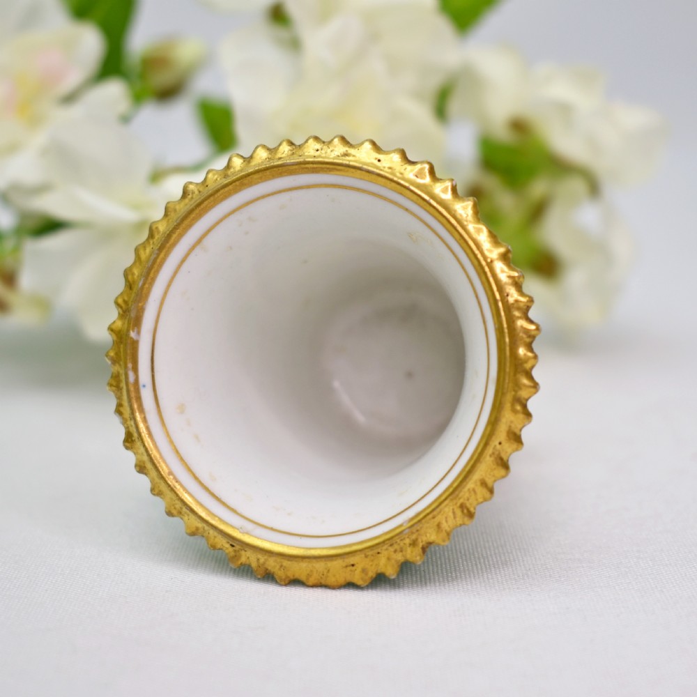 A miniature green Regency porcelain vase featuring a hand-painted exotic bird vignette framed in gold gilding upon a square pedestal base. View VII