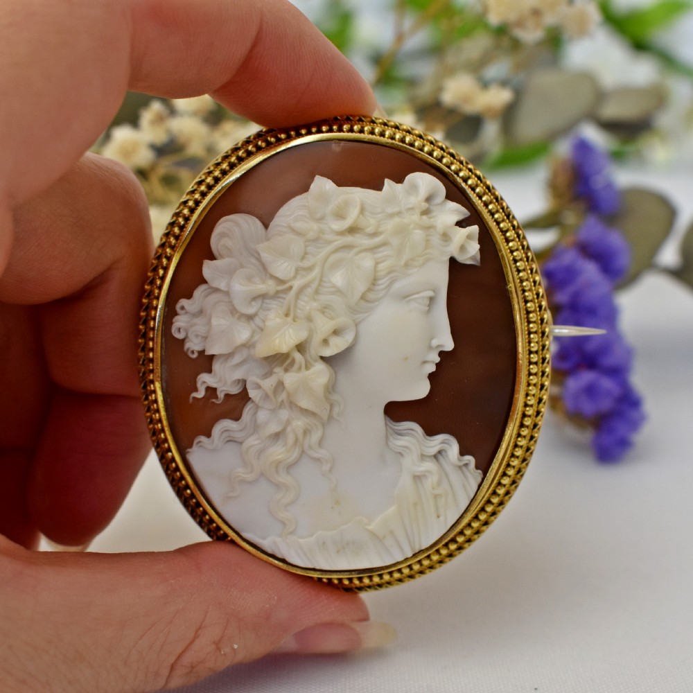 An oval Victorian cameo brooch featuring a white carved relief profile of Goddess Flora set within an 18ct gold frame with a twisted wire border. View III