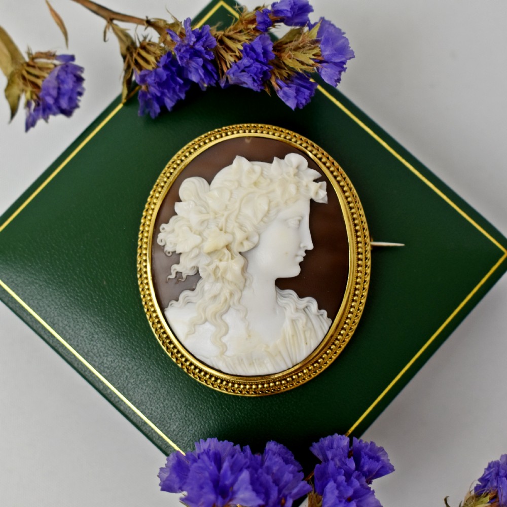 An oval Victorian cameo brooch featuring a white carved relief profile of Goddess Flora set within an 18ct gold frame with a twisted wire border. View VII