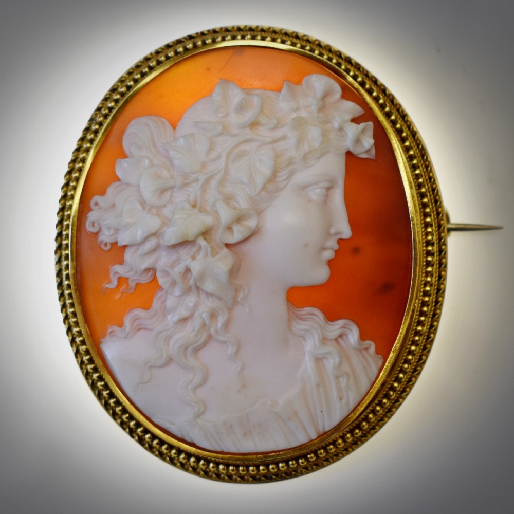 An oval Victorian cameo brooch featuring a white carved relief profile of Goddess Flora set within an 18ct gold frame with a twisted wire border. View VIII