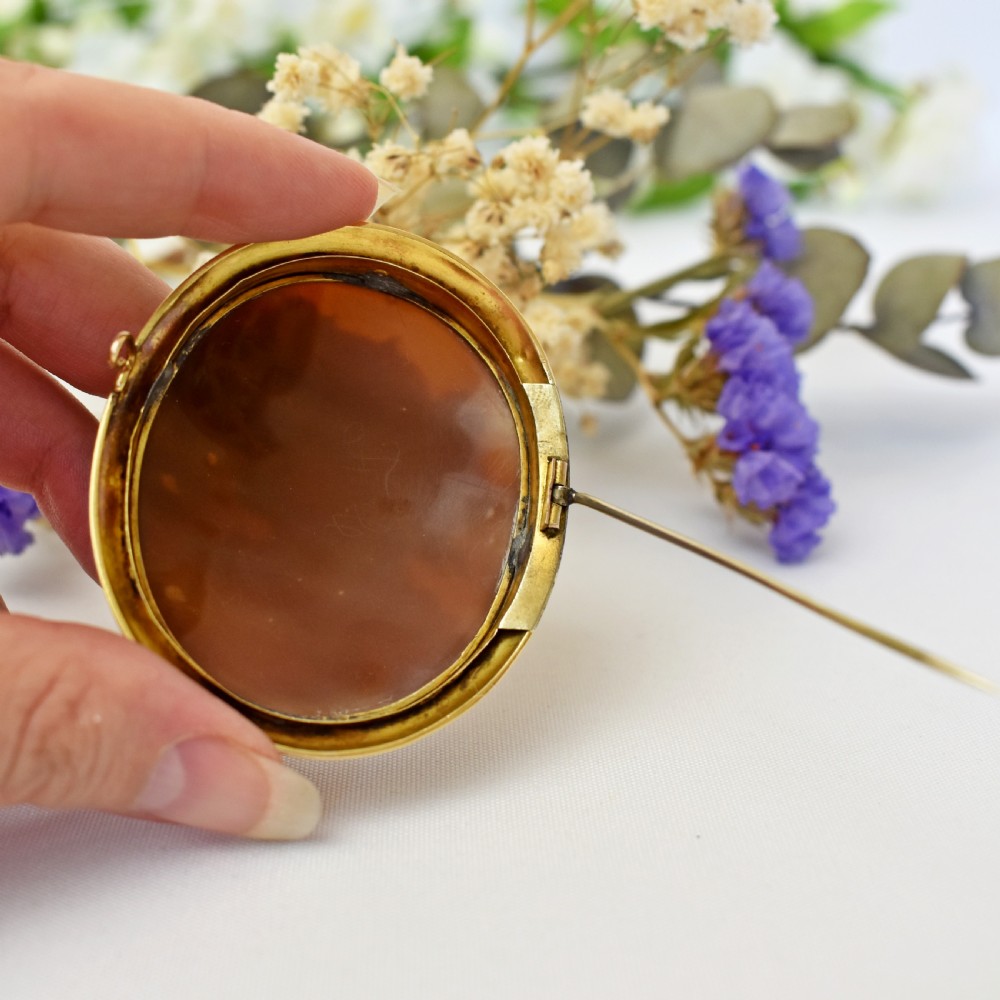 An oval Victorian cameo brooch featuring a white carved relief profile of Goddess Flora set within an 18ct gold frame with a twisted wire border. View X