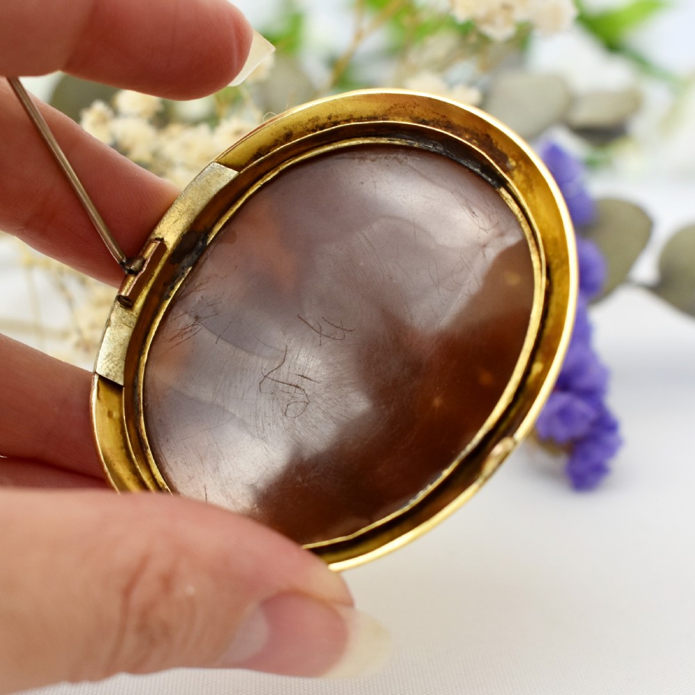 An oval Victorian cameo brooch featuring a white carved relief profile of Goddess Flora set within an 18ct gold frame with a twisted wire border. View XI