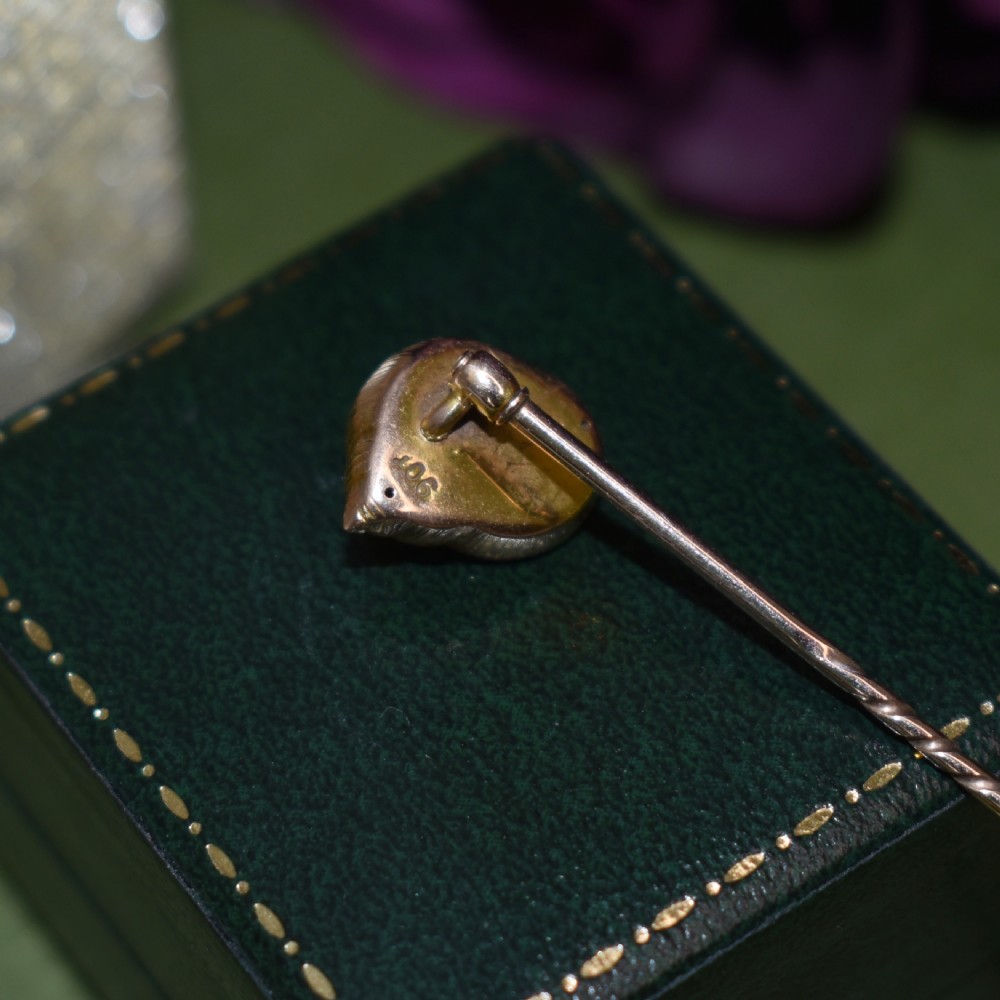 An Edwardian yellow gold stick pin featuring a textured shell casing enclosing a natural baroque pearl. View VIII