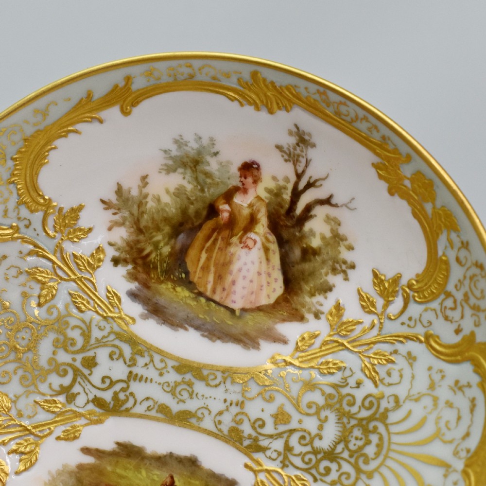 A nineteenth-century KPM Berlin porcelain teacup and matching saucer featuring gilded relief scrollwork and hand-painted figures in a landscape. View VII