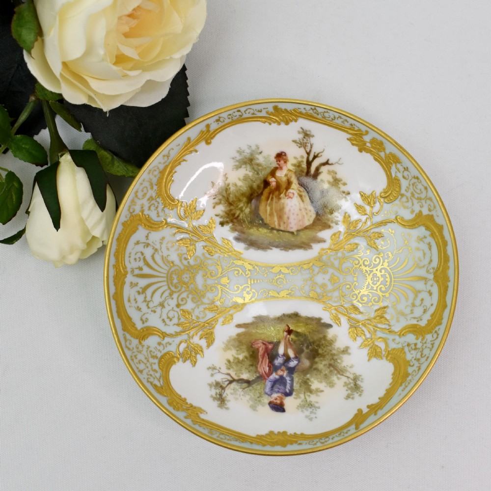A nineteenth-century KPM Berlin porcelain teacup and matching saucer featuring gilded relief scrollwork and hand-painted figures in a landscape. View XI