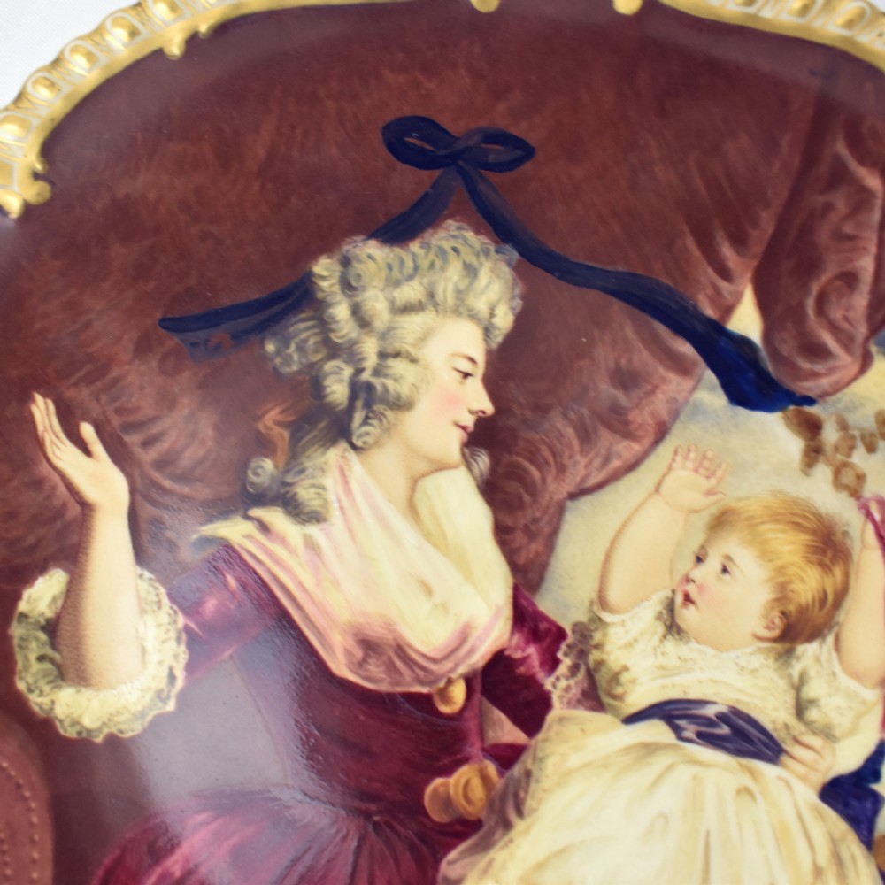An Edwardian Coalport porcelain cabinet plate featuring a hand-painted portrait of a lady and child within a gold gilded scalloped rim. View III