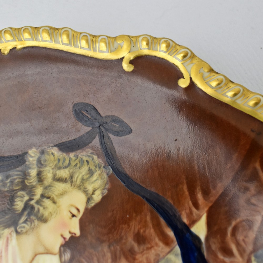 An Edwardian Coalport porcelain cabinet plate featuring a hand-painted portrait of a lady and child within a gold gilded scalloped rim. View VII