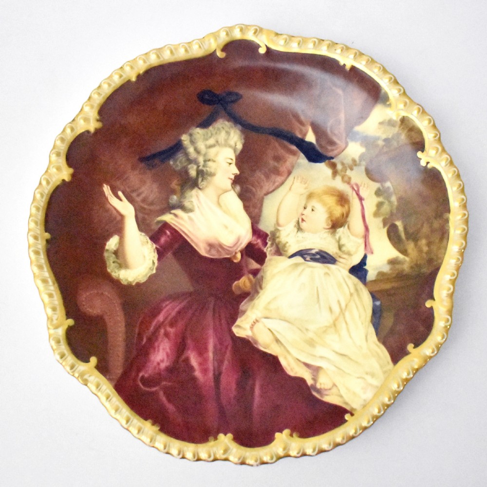 An Edwardian Coalport porcelain cabinet plate featuring a hand-painted portrait of a lady and child within a gold gilded scalloped rim. View VIII