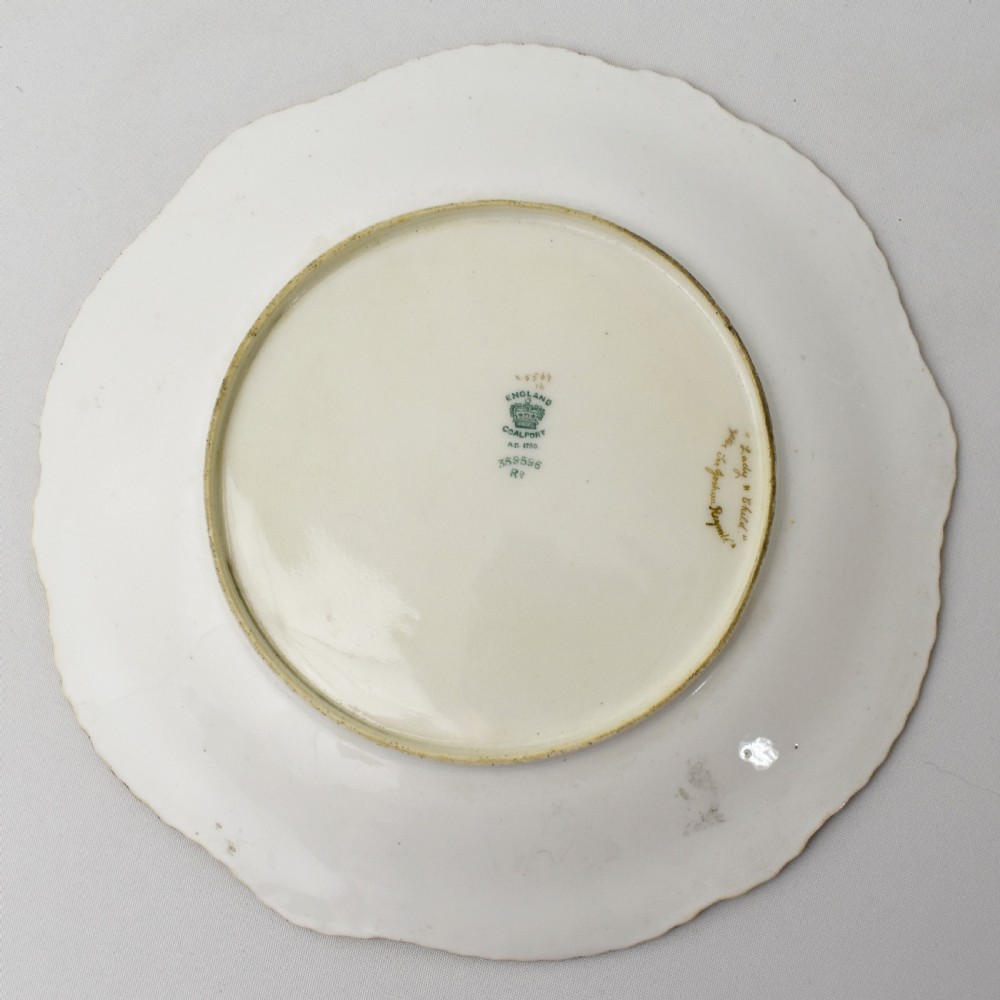 An Edwardian Coalport porcelain cabinet plate featuring a hand-painted portrait of a lady and child within a gold gilded scalloped rim. View IX
