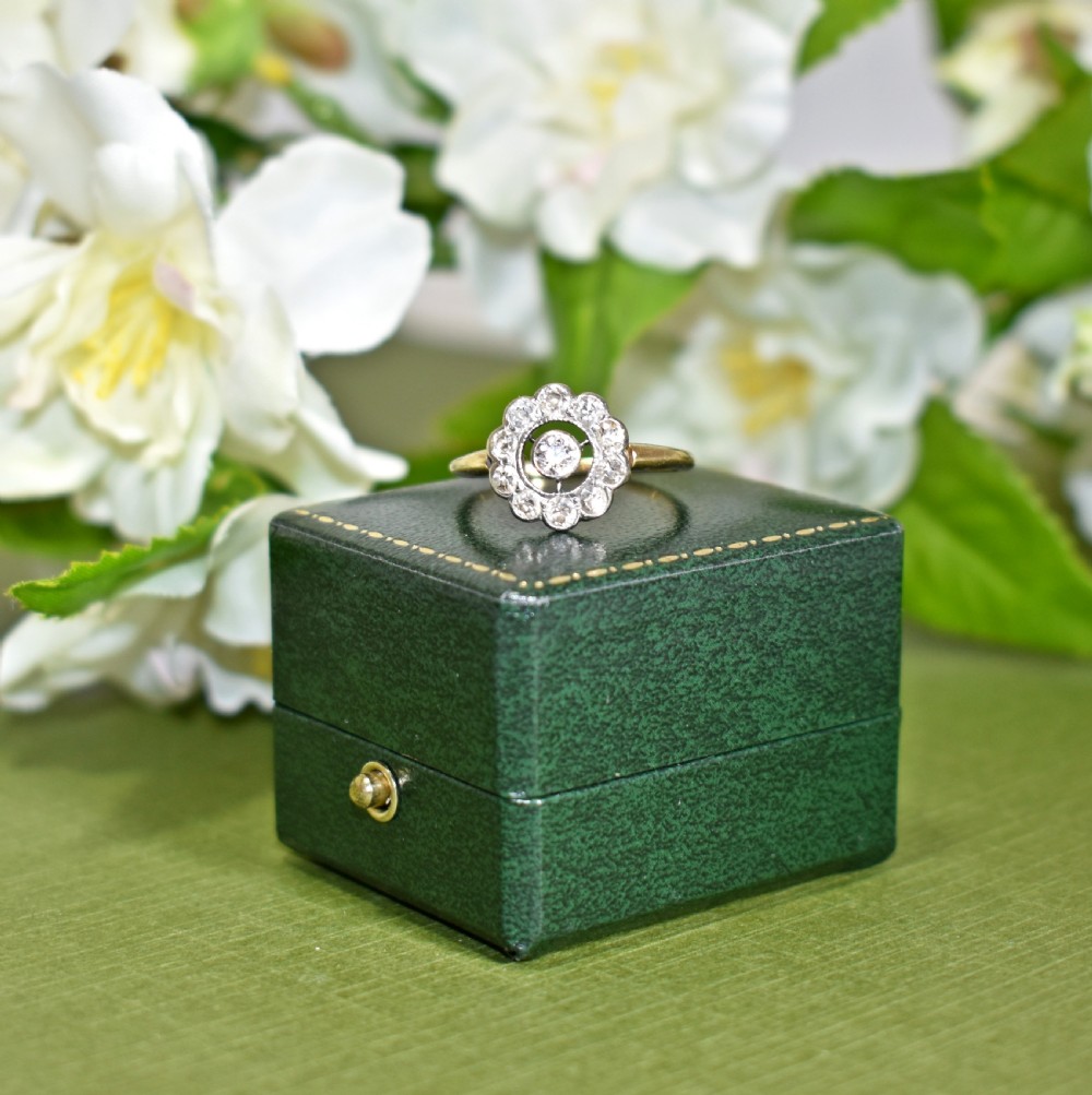 An Art Deco target ring featuring a central round diamond surrounded by a black ring and a scalloped outer border of diamonds set on an 18ct gold band. View II