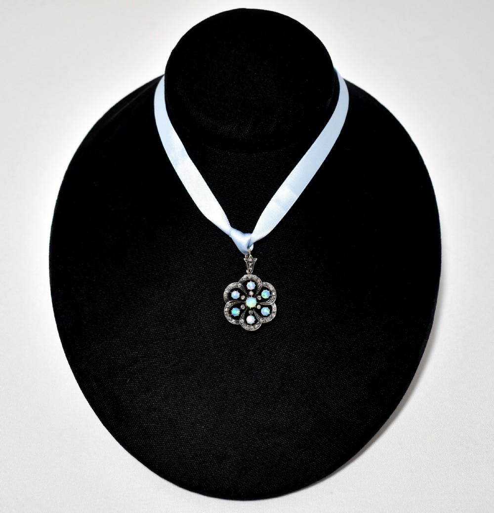 A late Victorian openwork floral pendant crafted from silver-topped gold, set with central and surrounding cabochon opals bordered by rose-cut diamonds. View II