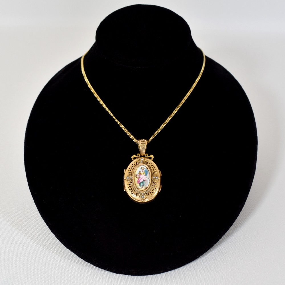 An oval 18ct gold Victorian locket pendant featuring a hand-painted enamel miniature of a figure surrounded by filigree work and seed pearls on a gold chain. View II