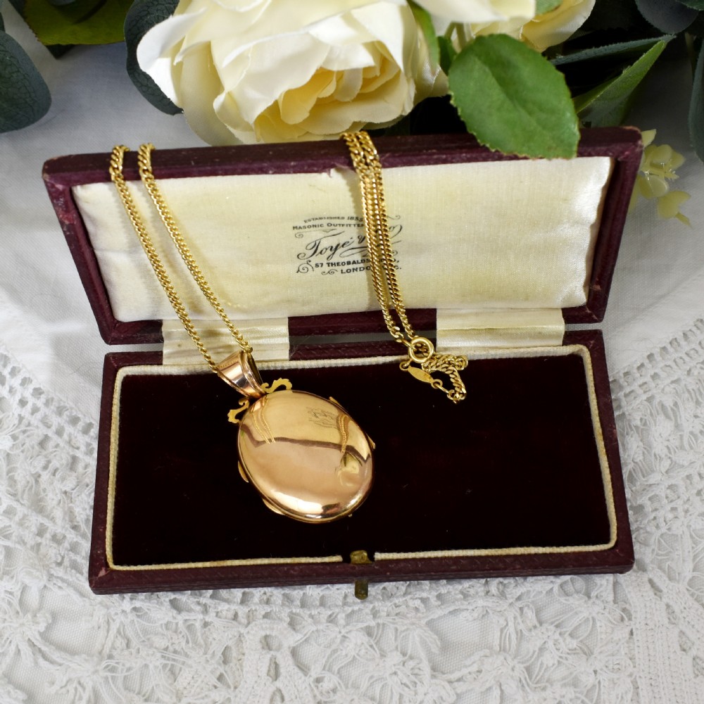 An oval 18ct gold Victorian locket pendant featuring a hand-painted enamel miniature of a figure surrounded by filigree work and seed pearls on a gold chain. View VIII
