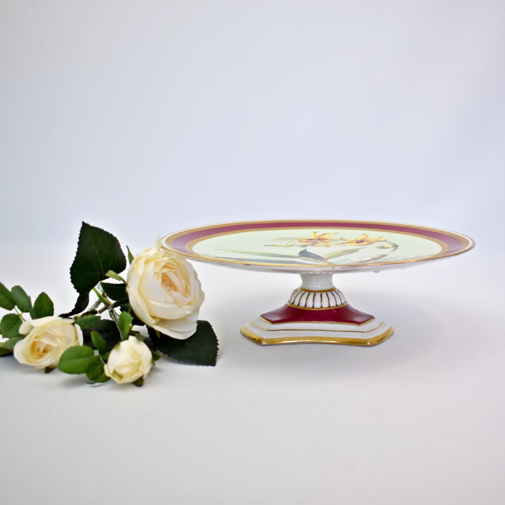 A circular Victorian porcelain tazza featuring a hand-painted yellow orchid illustration framed by a magenta border and beaded gilt rims. View II
