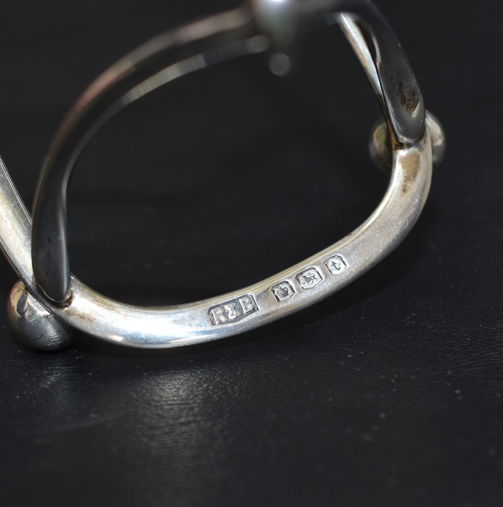 An antique sterling silver four-slot toast rack featuring wishbone-shaped dividers, a central loop handle, and ball feet. View VIII