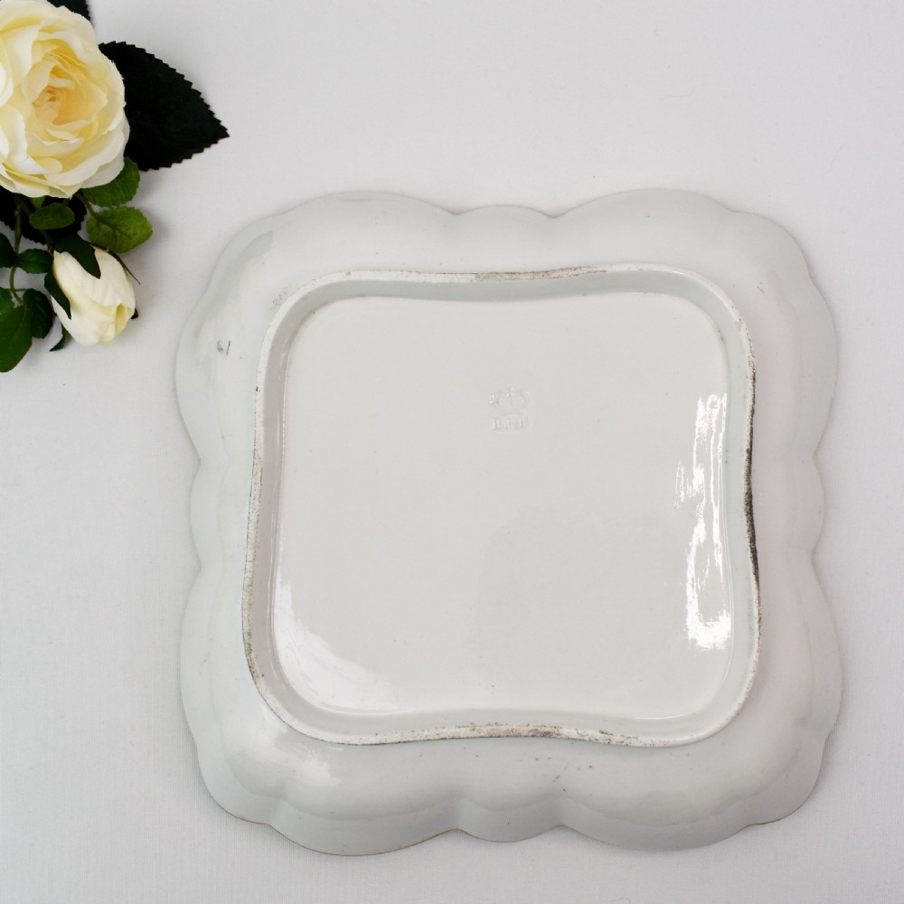A square lobed white porcelain dish decorated with intricate gold scrollwork around a central hand-painted yellow butterfly medallion. View VI