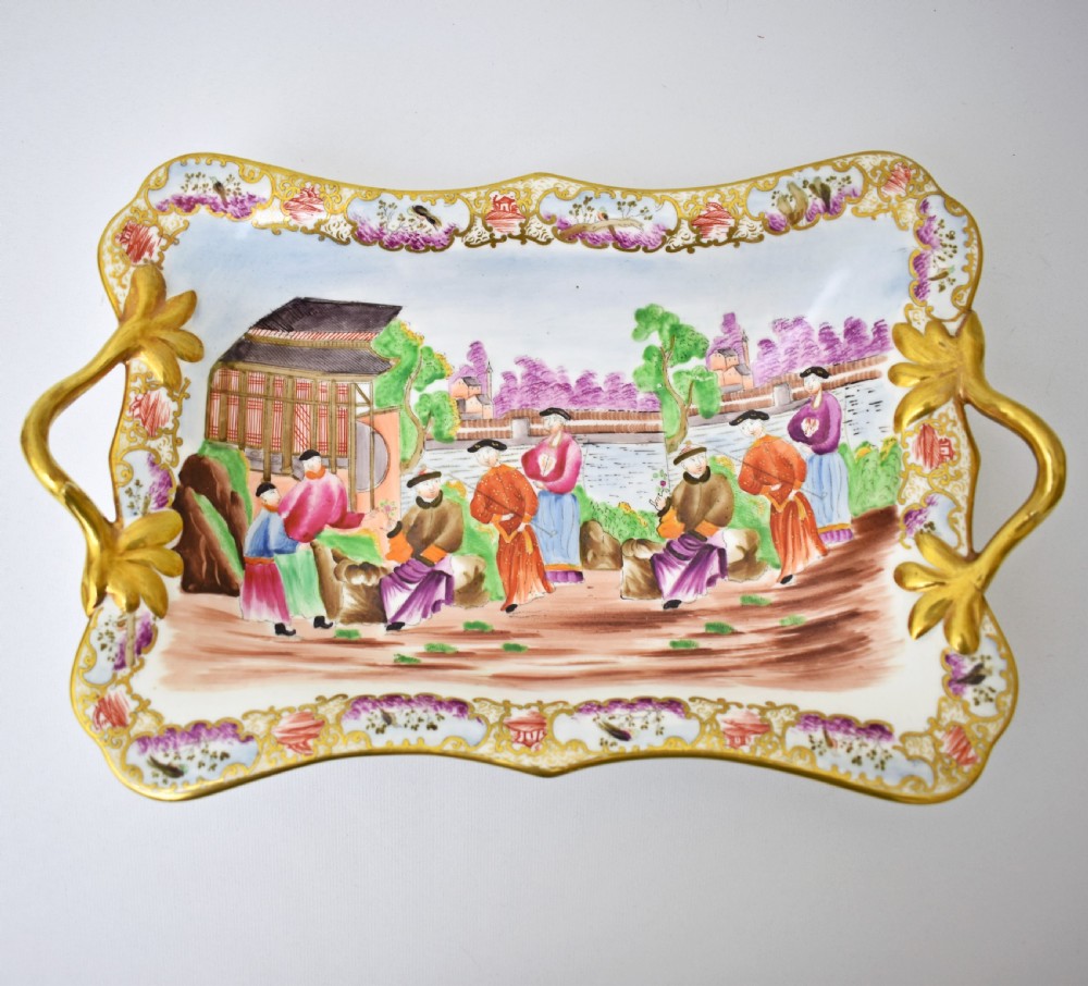 A Regency-era rectangular Swansea porcelain comport featuring gilded twin handles, a shaped border, and a polychrome hand-painted Mandarin Chinoiserie landscape scene. View II