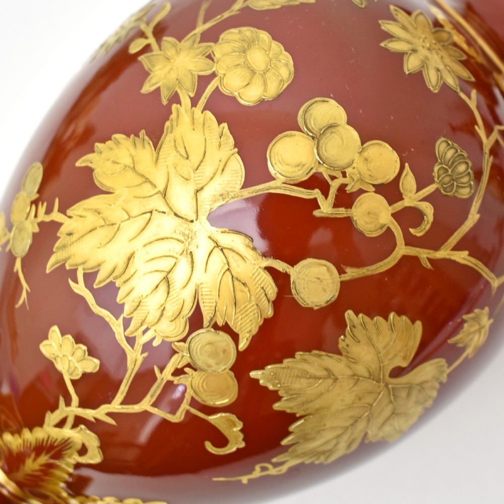 A Victorian Royal Crown Derby porcelain ewer with a terracotta brown ground, single loop handle, flared spout, and raised gold floral gilding on a square pedestal base. View VIII