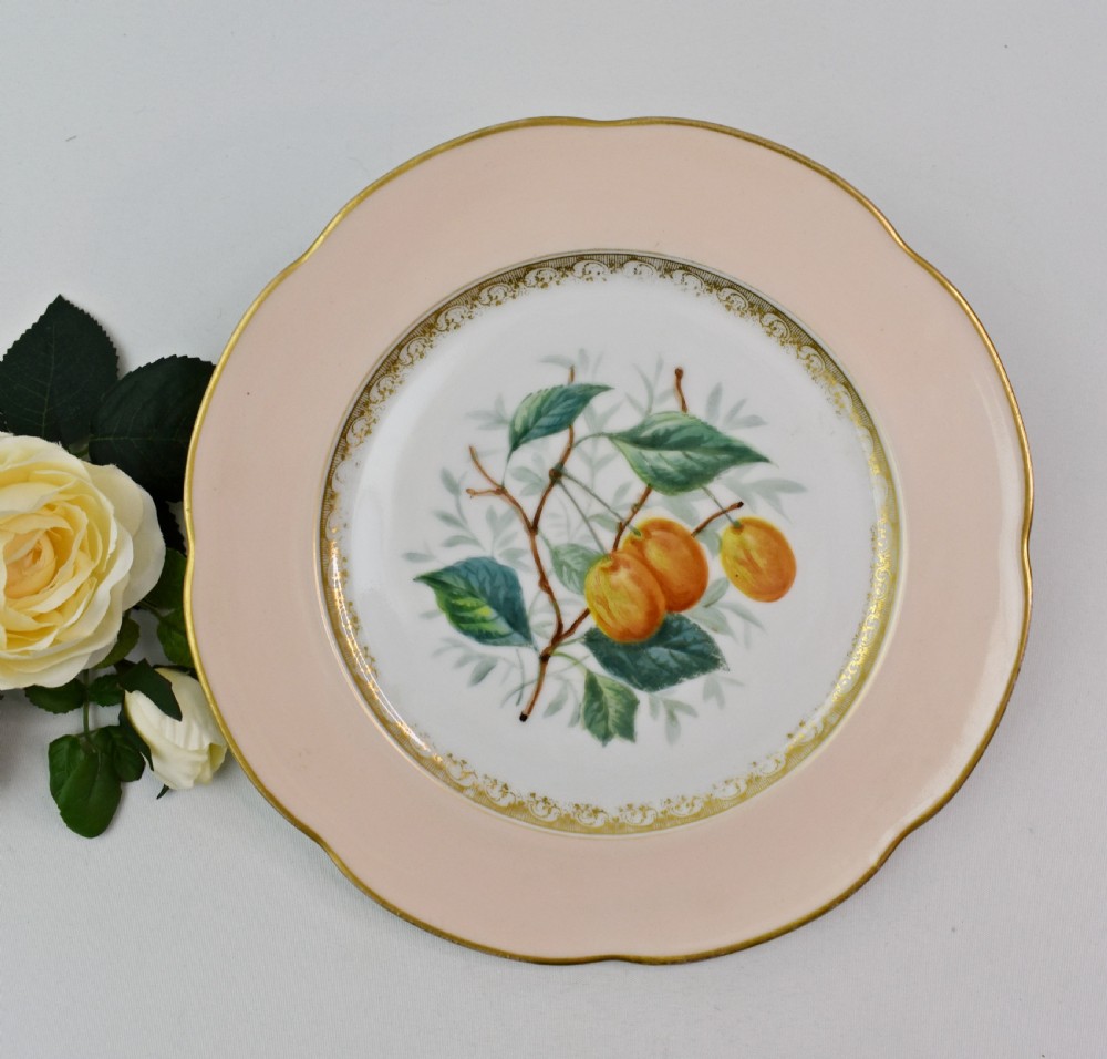 A set of four circular Russian porcelain plates decorated with hand-painted botanical fruit motifs, blush pink borders, and scalloped gilded rims. View III