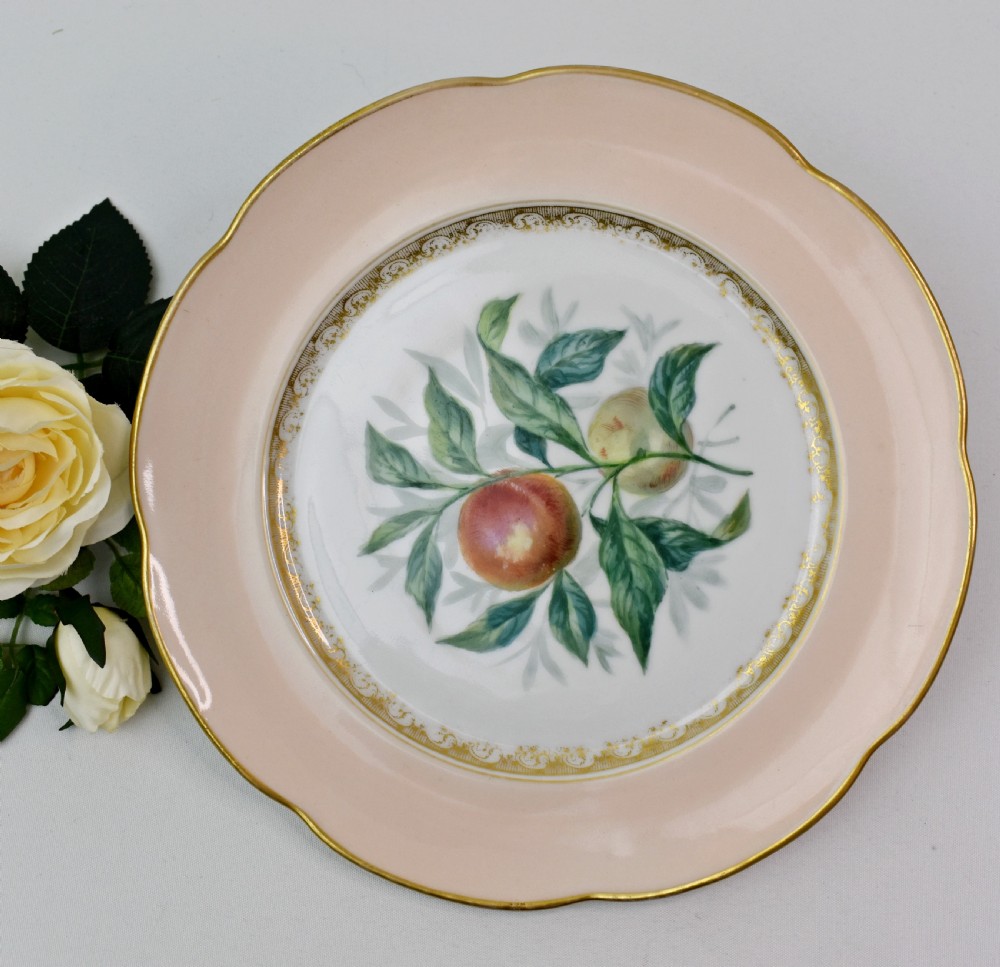 A set of four circular Russian porcelain plates decorated with hand-painted botanical fruit motifs, blush pink borders, and scalloped gilded rims. View VIII