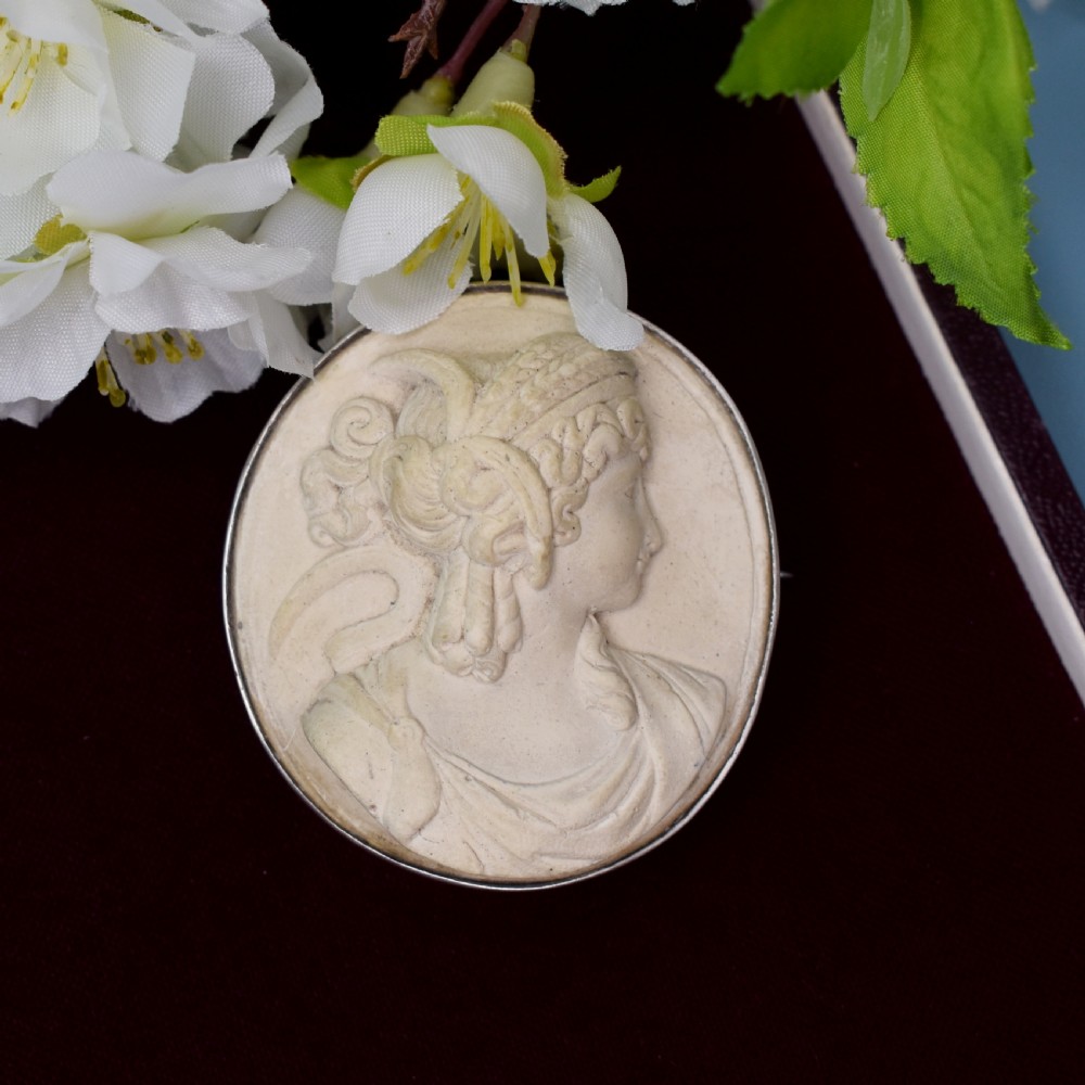 An oval Victorian lava stone brooch featuring a carved high-relief profile portrait of Demeter enclosed in a silver bezel setting. View II