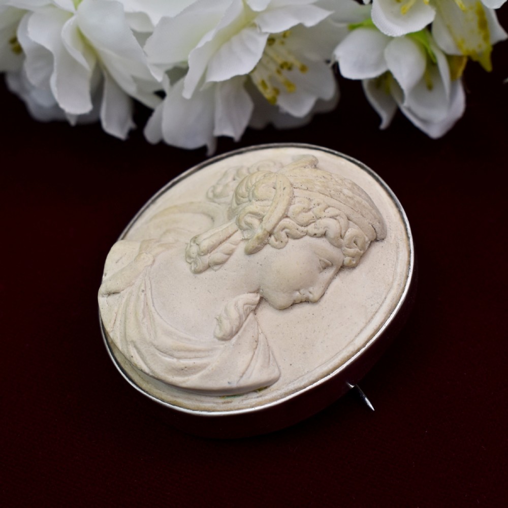 An oval Victorian lava stone brooch featuring a carved high-relief profile portrait of Demeter enclosed in a silver bezel setting. View III