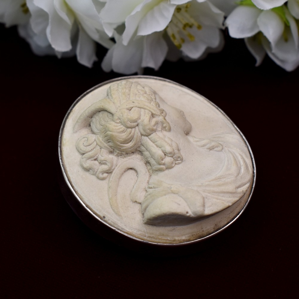 An oval Victorian lava stone brooch featuring a carved high-relief profile portrait of Demeter enclosed in a silver bezel setting. View V