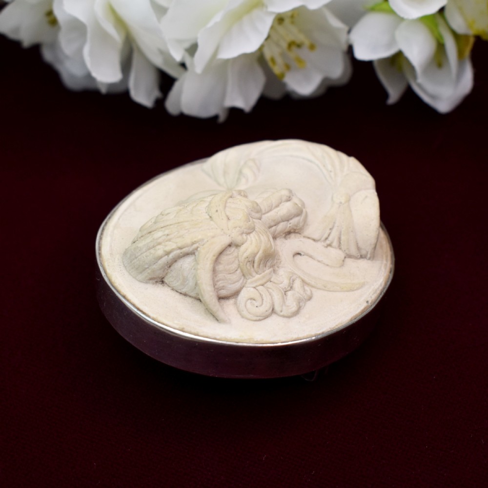 An oval Victorian lava stone brooch featuring a carved high-relief profile portrait of Demeter enclosed in a silver bezel setting. View VI