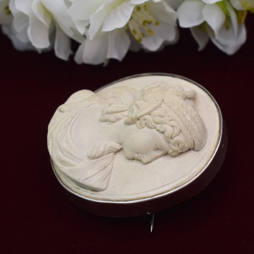 An oval Victorian lava stone brooch featuring a carved high-relief profile portrait of Demeter enclosed in a silver bezel setting. View VII