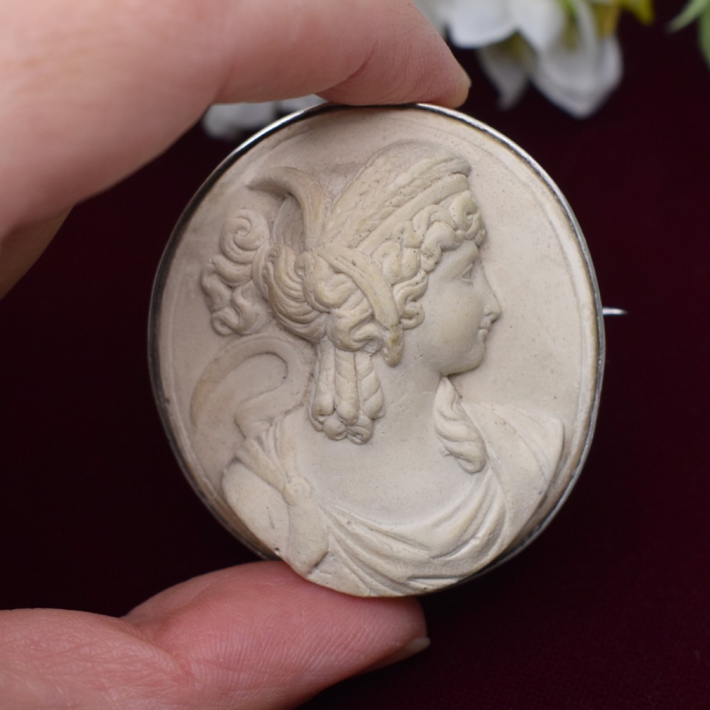 An oval Victorian lava stone brooch featuring a carved high-relief profile portrait of Demeter enclosed in a silver bezel setting. View VIII