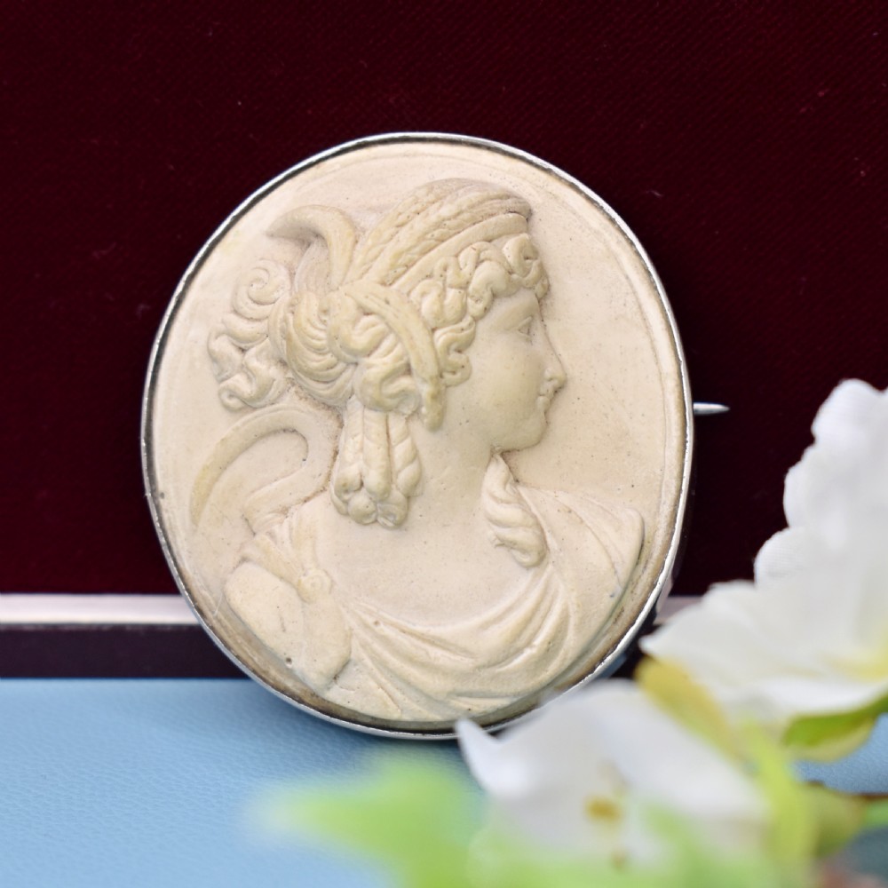 An oval Victorian lava stone brooch featuring a carved high-relief profile portrait of Demeter enclosed in a silver bezel setting. View IX