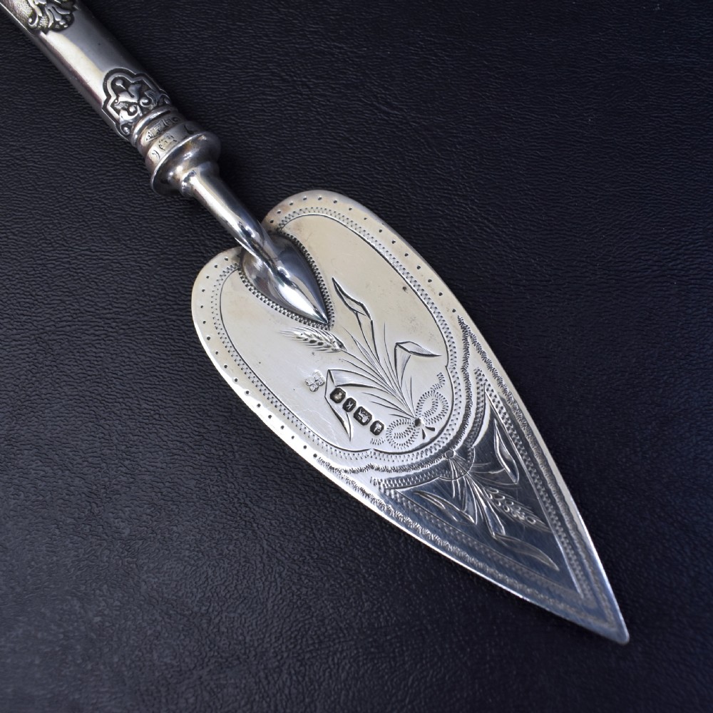 A Victorian sterling silver pastry server with a pointed trowel-shaped blade engraved with floral motifs and an ornate relief handle. View III