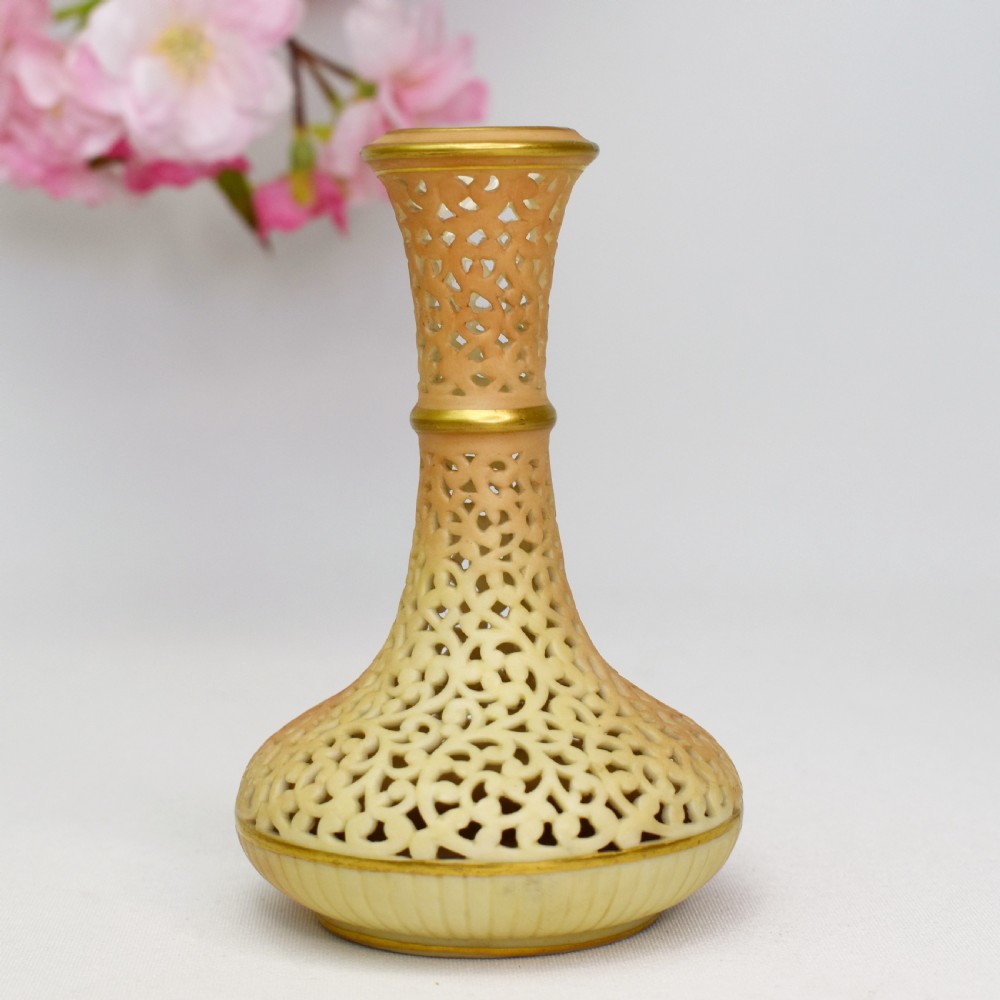A Victorian Grainger Worcester reticulated porcelain bud vase with pierced openwork lattice decoration and gilded accents.