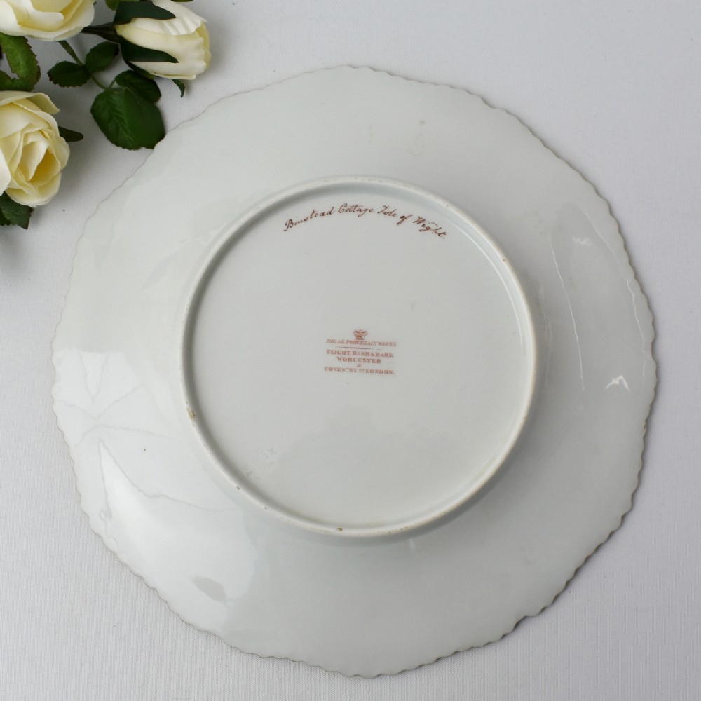 A Regency porcelain dessert plate featuring a hand-painted central landscape surrounded by intricate gold gilt seaweed patterns on a scalloped white border. View VI